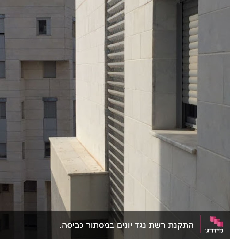 קיר בניין עם חלון ותריסים סגורים